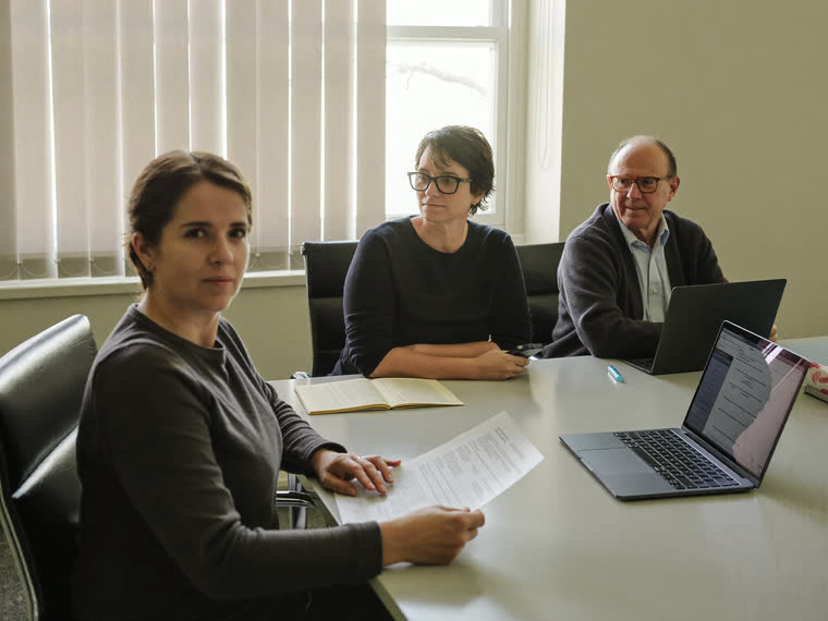 An accountant reviewing paperwork at a table with an older couple.